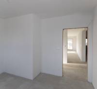 Empty room in a family house with a concrete floor and white walls.