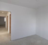 Empty room with white walls and a concrete floor in a family house.