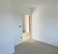 White wall with a door opening, concrete floor, ready for construction in a family house.