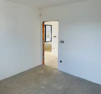 Empty room in a family house with a concrete floor and unfinished walls.