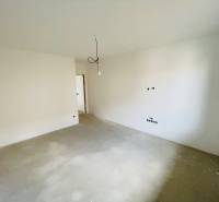 An empty room in a family house with an unfinished light bulb and white walls.