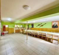 Spacious gastro spaces with wooden furniture and decorations on green walls.