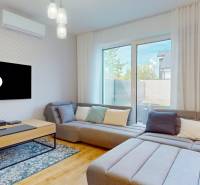 Living room in a 5 or more room apartment with a comfortable sofa and a TV on the wall.