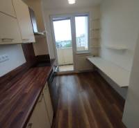 A kitchen in a 3-room apartment with a wooden countertop and access to a balcony.