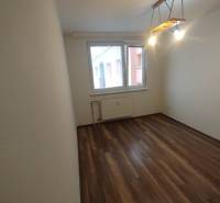 A room in a 3-room apartment with a wooden floor and a large window.
