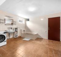A bathroom in a family house with a bathtub, sink, and washing machine.