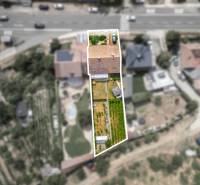 Aerial view of a family house in Vinosady with an adjacent garden and surroundings.
