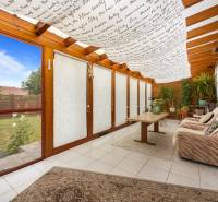 A winter garden in a family house with a sofa and plants, view of the lawn.