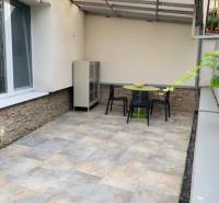 A terrace with tables and chairs in a 2-room apartment on Palisády Street.
