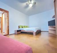 Bedroom with a bed, television, and sofa in a three-room apartment.