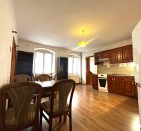 Dining room and kitchen in a 3-room apartment with wooden furniture and a dining table.