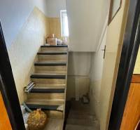 A staircase in a family house with wooden steps and storage space underneath.