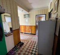 A hallway in a family house with retro wallpaper and a tiled floor.