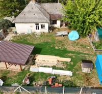 A family house in Kolárovo with a lawn, a shelter, a cart, and a vegetable garden.
