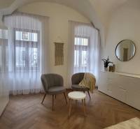 Interior of a 2-room apartment with chairs, a table, and a sideboard with decorations.