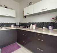 A kitchen with dark cabinets in a studio apartment.
