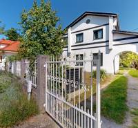 A family house on Mandľová Street in Bratislava - Jarovce surrounded by greenery and a sidewalk.