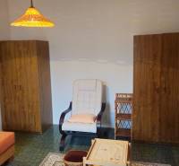 Living room with cabinets, an armchair, and a table in a studio apartment.