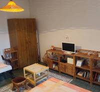 Living room in a studio apartment with a comfortable armchair and wooden furniture.