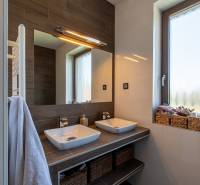 A bathroom in a family house with hanging sinks, baskets, and a large mirror.
