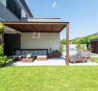 Outdoor seating by the pool of a family house in Kvetoslavov, surrounded by greenery.