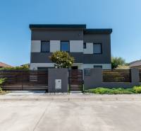 A family house in Kvetoslavov, with a gray facade and a wooden fence in front of the house.