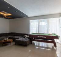 Living room in a family house with a pool table and a comfortable sofa.