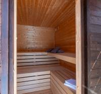 Interior of a sauna with wooden paneling and benches in a family house.