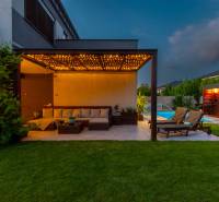 A family house in Kvetoslavov with a terrace, garden lighting, and a swimming pool in the evening atmosphere.