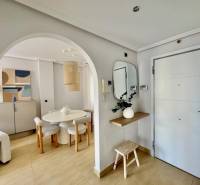 A stylish entrance hallway with an arched passage and light furniture in a holiday apartment.