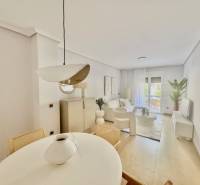 Spacious interior of a holiday apartment with light furniture and a dining table.