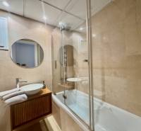 Bathroom with a round mirror, shower corner, and sink in a Holiday Apartment.