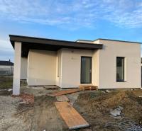 Construction of houses in Western Slovakia with a modern single-story house and unfinished landscaping.