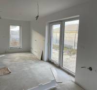 An empty room with large windows, tiles, and prepared cables - House construction.
