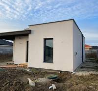 Construction of a house in Western Slovakia with a light facade and unkempt surroundings.