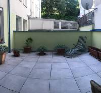 Spacious terrace in a 3-room apartment with flower pots and a lounger for relaxation.