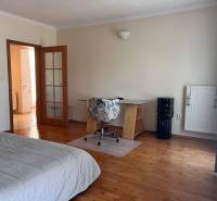 Bedroom in a 3-room apartment with a desk and wooden floor.