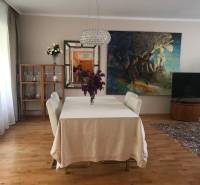 Dining room with a painting, a white table, and a shelf in a 3-room apartment.