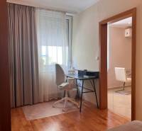 A workspace in a 3-room apartment with a white chair and a desk by the window.