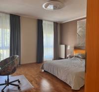 Bedroom in a 3-room apartment, bright room with a bed, chair, and large windows.