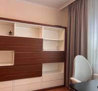 A shelving cabinet and curtains in a 3-room apartment with a bright interior.