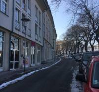 Winter street Zámocká in Bratislava with cars and buildings.