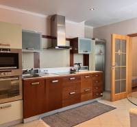 A kitchen with a wooden cabinet in a 3-room apartment, open doors to the room.