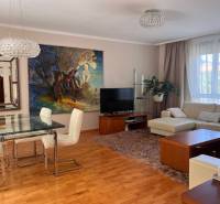 Living room in a 3-room apartment with a sofa, dining table, and a painting on the wall.