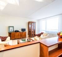 Living room with a sofa, wooden furniture, and a table with a bowl of fruit in a 3-room apartment.