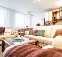3-room apartment with a comfortable sofa, dining table, and kitchen unit with an extractor hood.