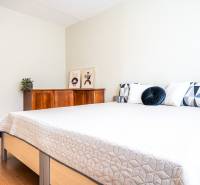 Bedroom in a 3-room apartment with a double bed and a wooden dresser.