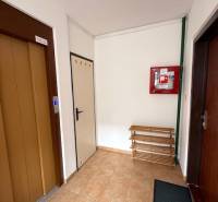 Entrance hall with an elevator and a bench in a 3-room apartment.