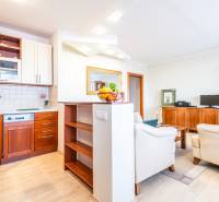 Living room in a 3-room apartment with a kitchen, wooden furniture, and a sofa set.