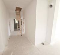 The interior of a family house with an access ladder to the attic. White walls and floor.